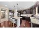 Well-lit kitchen featuring dark wood cabinets, granite countertops, stainless steel appliances, and a spacious island at 2575 Mccracken Ln, Castle Rock, CO 80104