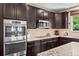 Functional kitchen with stainless steel appliances, dark wood cabinets, granite countertops, and a gas cooktop at 2575 Mccracken Ln, Castle Rock, CO 80104