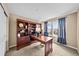 Home office featuring a dark wood desk, built-in bookcase, and bright windows with neighborhood views at 2575 Mccracken Ln, Castle Rock, CO 80104