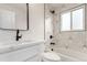 Modern bathroom with stylish fixtures and a tub with shower and tiled wall, exuding sophistication at 855 Newark St, Aurora, CO 80010