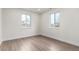 Bright bedroom with hardwood floors and ample natural light from two windows, creating a welcoming space at 855 Newark St, Aurora, CO 80010