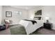 A bedroom includes a large bed, a plush rug, lots of natural light, and calming decor at 855 Newark St, Aurora, CO 80010