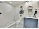 Modern bathroom with blue vanity, walk-in shower, and patterned floor at 6749 Ingalls St, Arvada, CO 80003