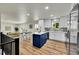 Modern kitchen with white cabinets, a blue island, and stylish backsplash at 6749 Ingalls St, Arvada, CO 80003