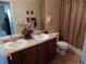Well-lit bathroom featuring a double sink vanity, toilet, and shower with neutral toned tile at 7354 Benton St, Arvada, CO 80003