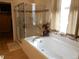 Bathroom featuring a tub with glass enclosure and window with a curtain at 7354 Benton St, Arvada, CO 80003