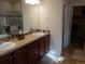 Bathroom with dual sinks, a tiled backsplash, and a shower with glass door at 7354 Benton St, Arvada, CO 80003