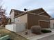 View of a home and its attached garage with rear-facing satellite dish at 7354 Benton St, Arvada, CO 80003