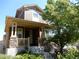 Charming two-story home showcasing a welcoming front porch with stone accents and landscaped front yard at 7354 Benton St, Arvada, CO 80003