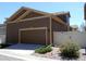 Detached two-car garage with ample parking space, situated next to a white privacy fence and well-kept landscaping at 7354 Benton St, Arvada, CO 80003