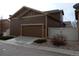 Attached garage with a brown door and ample driveway space at 7354 Benton St, Arvada, CO 80003