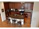 Kitchen featuring dark wood cabinetry, stainless steel appliances and spacious center island at 7354 Benton St, Arvada, CO 80003