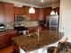 Kitchen featuring dark wood cabinetry, stainless steel appliances and spacious center island at 7354 Benton St, Arvada, CO 80003