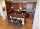 The eat in kitchen features stainless steel appliances, a breakfast bar with stool seating, and hardwood floors at 7354 Benton St, Arvada, CO 80003