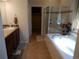 Bright and airy main bathroom featuring a separate shower, soaking tub, and a spacious vanity area at 7354 Benton St, Arvada, CO 80003