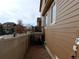 Side yard of a home with a brick walkway leading to a deck at 7354 Benton St, Arvada, CO 80003