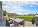 A beautifully staged outdoor dining area with a view of the well-manicured backyard at 16500 Timber Cove St, Hudson, CO 80642