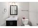 Powder room with a black vanity, modern fixtures, and a white toilet at 16500 Timber Cove St, Hudson, CO 80642