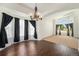 Formal dining area with hardwood floors, decorative chandelier, and large windows offering an elegant setting at 16500 Timber Cove St, Hudson, CO 80642