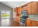 Kitchen area features wood cabinets, granite countertops, stainless steel appliances, and access to the backyard at 16500 Timber Cove St, Hudson, CO 80642