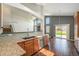 Open kitchen with wood cabinets, granite countertops, stainless steel appliances, and dark hardwood floors at 16500 Timber Cove St, Hudson, CO 80642