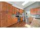 Kitchen with stainless steel appliances, tiled backsplash, and wooden cabinets offers a functional and stylish cooking space at 16500 Timber Cove St, Hudson, CO 80642