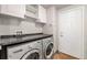 Laundry room with a white cabinets, countertop, washer and dryer, and a door to the outside at 16500 Timber Cove St, Hudson, CO 80642