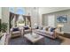 Bright living room boasts large windows, plush seating, and neutral decor for a comfortable and inviting space at 16500 Timber Cove St, Hudson, CO 80642