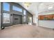Spacious living room featuring vaulted ceilings, large windows, and a view of the kitchen at 16500 Timber Cove St, Hudson, CO 80642
