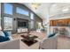 Open living room featuring vaulted ceilings, large windows, and a view of the kitchen and dining area at 16500 Timber Cove St, Hudson, CO 80642