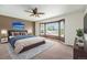 Tranquil main bedroom showcasing a bay window, a ceiling fan, and a comfortable bed at 16500 Timber Cove St, Hudson, CO 80642