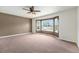 Carpeted main bedroom showcasing a bay window and a ceiling fan at 16500 Timber Cove St, Hudson, CO 80642