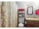 Cozy bathroom featuring a shower, toilet, vanity, and a practical storage shelf for towels and essentials at 6838 S Broadway, Centennial, CO 80122