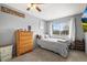 Bright bedroom featuring a ceiling fan, dresser, and a window, creating a relaxing and inviting atmosphere at 6838 S Broadway, Centennial, CO 80122