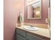 Compact powder room featuring peach walls, a stylish sink, and a vanity at 6838 S Broadway, Centennial, CO 80122