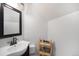 Cozy powder room with a sleek dark wood vanity, white sink and woven decor at 3629 Kalamath St, Denver, CO 80211