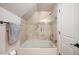 Tiled tub-shower combo with glass door and a crisp white paneled door nearby at 3629 Kalamath St, Denver, CO 80211