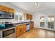 Bright kitchen features stainless steel appliances, wood cabinets and opens to a patio at 3629 Kalamath St, Denver, CO 80211
