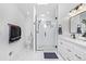 Newly remodeled bathroom featuring a glass shower, white vanity, and marble floors at 6062 S Newport St, Centennial, CO 80111