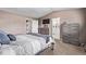 Large bedroom featuring ensuite bathroom, two dressers, and beige carpet at 6062 S Newport St, Centennial, CO 80111