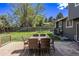 A deck with a wood table and six chairs overlooks a grassy backyard with a wood fence at 6062 S Newport St, Centennial, CO 80111