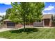 Home featuring an attached two-car garage, brick accents, and a large tree in the front yard at 6062 S Newport St, Centennial, CO 80111