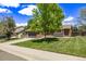 Two-story home with a well-maintained lawn, mature trees, a two-car garage, and a paved sidewalk at 6062 S Newport St, Centennial, CO 80111