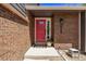 Charming front entry features a bright red door with a decorative window and a welcoming Hello mat at 6062 S Newport St, Centennial, CO 80111