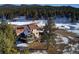 Stunning aerial view of home in a serene, snow-covered landscape with mature trees at 5371 Hazel Rd, Evergreen, CO 80439