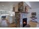 Stone fireplace with a wood mantel, set between the dining area and kitchen at 5371 Hazel Rd, Evergreen, CO 80439