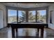 The game room features a pool table and bright windows with mountain views at 5371 Hazel Rd, Evergreen, CO 80439
