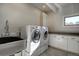 Well-lit laundry room includes modern washer, dryer, sink, and ample counter space at 5371 Hazel Rd, Evergreen, CO 80439