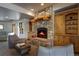 Cozy living room features a stone fireplace with log mantle and built-in wooden cabinets at 5371 Hazel Rd, Evergreen, CO 80439
