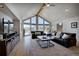 Spacious living room with vaulted ceilings, large windows, and hardwood floors at 5371 Hazel Rd, Evergreen, CO 80439